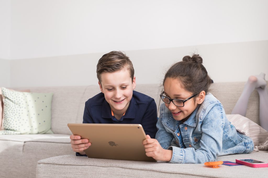 Jongen en meisje kijken samen op een tablet, met Mytimingcards tijdskaarten